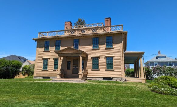 An external photo of Quincy House showing the front of the house and the green front lawn.