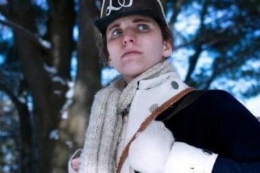 A photo of a woman in a Revolutionary War soldier's uniform.